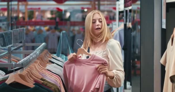 Зависимость Покупок Красивая Блондинка Ищет Продукт Одежды Центре Рынка Привлекательная — стоковое видео