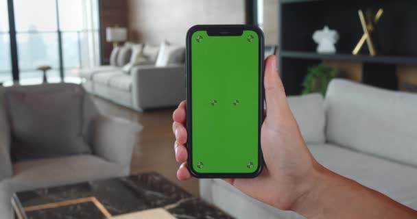 Чоловік Тримає Мобільний Телефон Руці Зеленим Екраном Ключа Хроми Вітальні — стокове відео