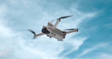 Drone Helikopteri havada çekim yapıyor. Gökyüzü arka planında modern dörtlü helikopter dronu. Quadcopter drone ile seyahat ederken video ve fotoğraf çekme kavramı. Ağır çekimde modern robot drone.