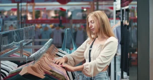 Ξανθές Γυναίκες Φαίνονται Προϊόν Των Ρούχων Στο Εμπορικό Κέντρο Κάνει — Αρχείο Βίντεο