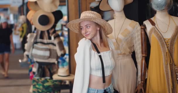 Χαρούμενη Ξανθιά Αγοραστής Προσπαθεί Για Ψάθινο Καπέλο Έννοια Των Εκπτώσεων — Αρχείο Βίντεο