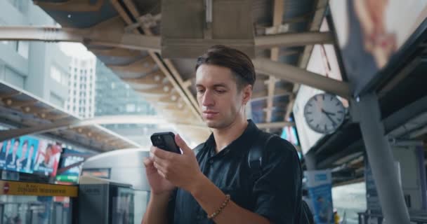 Молодий Чоловік Використовує Смартфон Станції Метро Очікуванні Прибуття Майбутнього Поїзда — стокове відео