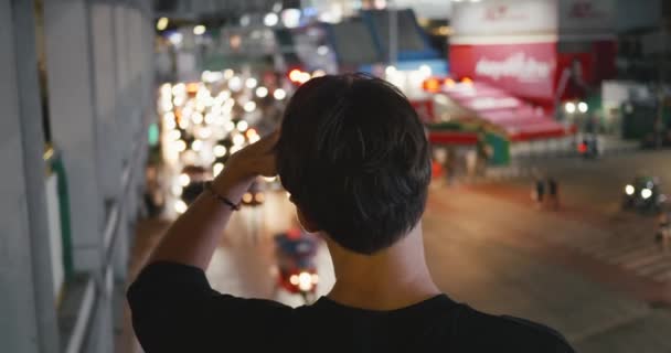 城市场景 后视镜男性用车灯看着夜晚的大城市街道 后视镜上的男子背景的夜车交通在市中心 男性游客在夜市看着路过的汽车 — 图库视频影像