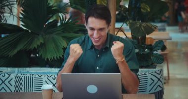 Yakışıklı ve kendine güvenen küçük işletme sahibi iyi bir anlaşma yaptı. Kafede dizüstü bilgisayarda çalışan iş adamı küçük işletme sahibi kavramını gösteriyor. Harika bir teklif, büyü artık.