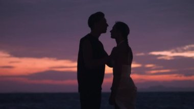 Romantik çift, karı koca gün batımında akşam kumsalında güzel bir anı paylaşıyorlar. Koca, karısını alnından nazikçe öper, sevgi ve ilgi gösterir. Denizde sevgili bir çiftin romantik akşamı