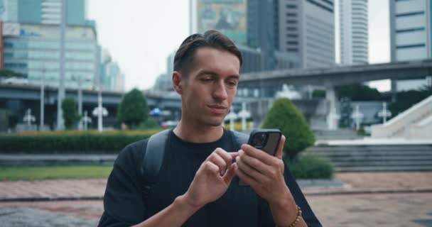 Şehir Caddesini Keşfederken Sırt Çantalı Bir Turist Cep Telefonu Kullanıyor — Stok video