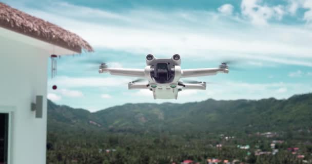 夏休み中に旅行ブロガーのコンテンツを撮影するためのゆっくりとした動きで空中飛行する現代の無人機クワッドコプター 熱帯の楽園を旅しながら空中観覧コンテンツを作るコンセプト — ストック動画