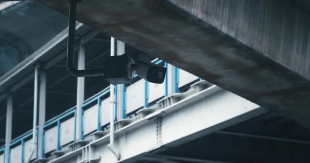 市内に設置された屋外監視カメラは 大都市の交通を制御するために橋下に設置された 大きい都市の建物の街をスキャンするCctvカメラの保証システム — ストック動画