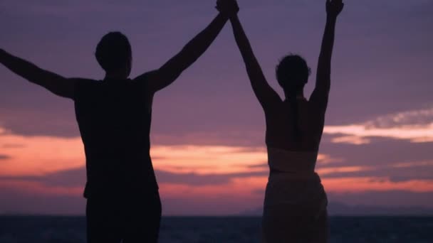 Силуетна Пара Піднімає Руки Разом Океанському Пляжі Відзначаючи Щасливі Миті — стокове відео