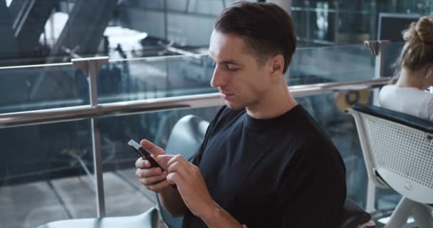 Beyaz Adam Havaalanı Terminalinde Akıllı Telefon Kullanarak Giriş Yapıyor Seyahat — Stok video