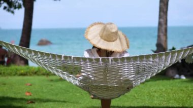Kadın rutin işleri bırakıp dinlenmek için adaya gitmeye karar verdi. Hamakta deniz kenarında ruh ve rahatlama için sihirli bir ilaç vardır. Adada rahatlatıcı bir tatil hisset..