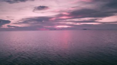 Pembe cennet denizi ya da sakin su manzaralı okyanus gündoğumu. Hava manzaralı güzel gün batımı ya da gün doğumu, deniz yüzeyinde uçan dron. Tropik bir akşamda sakin bir su manzarası. Deniz manzarasına güneş yansıması