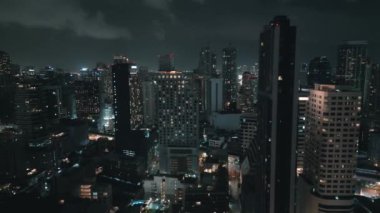 Geceleri ışıklar açıkken gökdelenin havadan çekilmiş görüntüsü. Metropolis 'in gece gökyüzüne bakan insansız hava aracı görüntüsü. Büyük şehirde karanlık destansı binalar. Aydınlatılmış şehir sokaklarının gece görüntüleri.