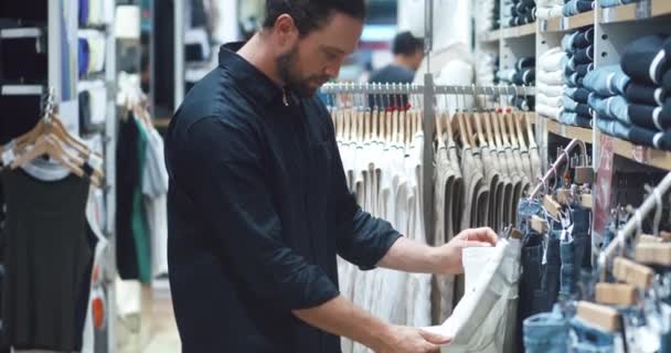 Menutup Pembeli Laki Laki Memilih Jeans Tergantung Rak Toko Pakaian — Stok Video