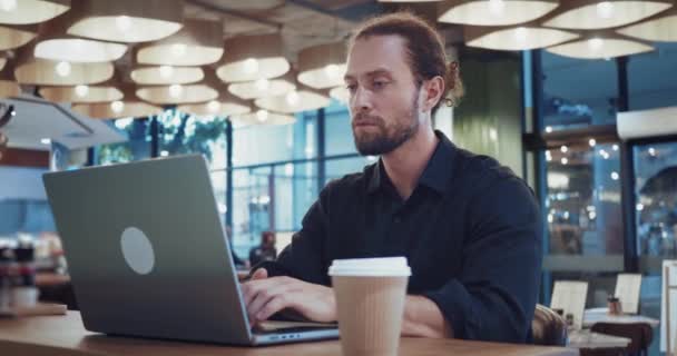 专心致志的男人坐在咖啡店里提高笔记本电脑的数字技能 数字技能 自由职业者使用计算机有效执行任务所需的一套技术能力 — 图库视频影像