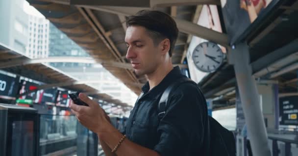 Turista Masculino Con Mochila Usando Smartphone Mientras Espera Tren Del — Vídeos de Stock