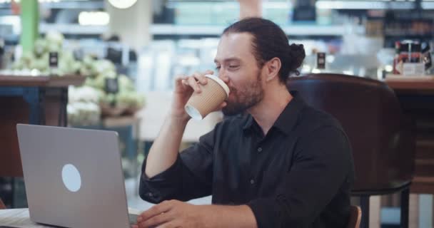 一个人正在发展一个创业企业 并试图正确地管理自己的时间 他坐在咖啡店里喝咖啡 还在电脑上查看数据 工作时间或时间管理概念 — 图库视频影像