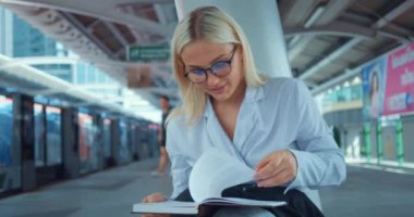 Metro istasyonunda kitap okuyan bir kadın. Mutlu gülümseme, heyecanlı zeki bayan öğrenci sayfa çevirip ilginç bilim kurgu edebiyatı okuyor. Sarışın kadın okumayı seviyor. Kitap okumayı seviyor.