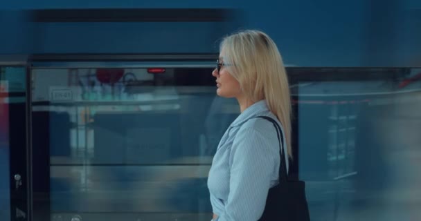 地铁里的女人在移动的火车前面企业经理女员工年轻女性平静地等待地铁列车上下班上班开始一天的工作 等候火车的工作日开始 — 图库视频影像