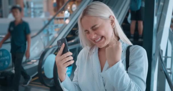 妇女在自动扶梯使用电话 喜形于色的积极女子笑着庆祝胜利好消息 难以形容的过度快乐表达快乐的积极情绪 — 图库视频影像