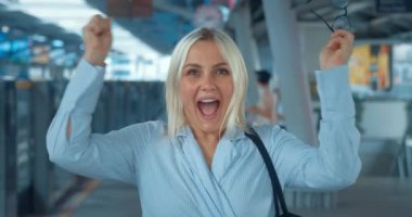 Sevinen, kutlayan, sevinen etkileyici bir kadın. Kadın bardakları yüksek sesle çıkarıyor inanılmaz bir neşe ve mutluluk ifade ediyor, el sıkışıyor, el çırpıyor. Şehir metrosundaki kadın.
