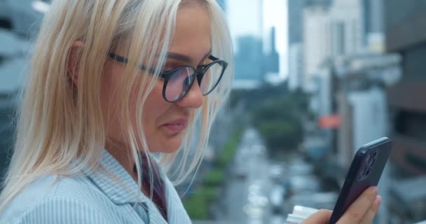 도시에서 전화를 클로즈업 초상화 금발의 여자가 인터넷을 메시지를 온라인 메신저에서 — 비디오