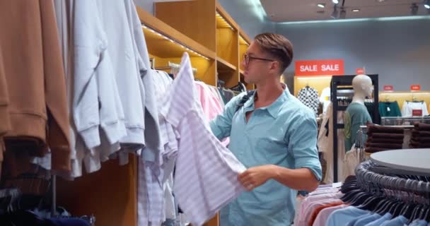 Seçenekleri Değerlendiren Kişi Mağazadaki Tişört Seçiminde Özenle Tişört Seçerek Kaliteli — Stok video