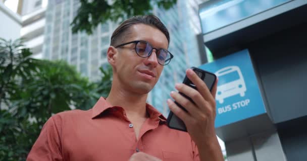 Otobüs Durağında Bekleyen Adam Otobüs Durağının Yerini Öğrenmek Için Telefonuna — Stok video