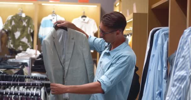 Při Hledání Dokonalého Oblečení Muž Uvažuje Stylové Šedé Bundy Výběr — Stock video
