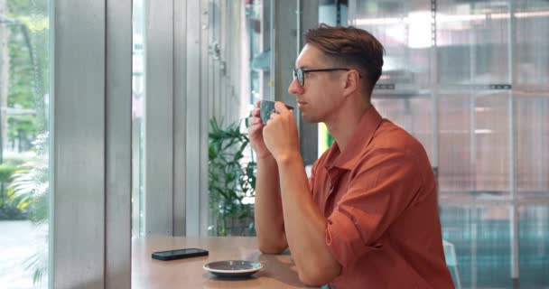 Uomo Pensieroso Con Gli Occhiali Siede Nel Caffè Gode Una — Video Stock