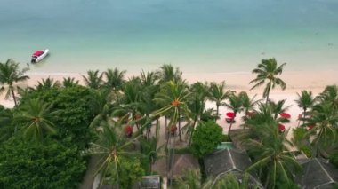 Sahilde avuç içi, okyanus sahili yıkar. Gezginler ve turistler için deniz kıyısına yakın bir yerleşim yeri. Göz kamaştırıcı temiz deniz kıyısı, kumlu sahil. Çatılar dolusu ev, palmiye ağaçları. Yukarıdan hava görünümü