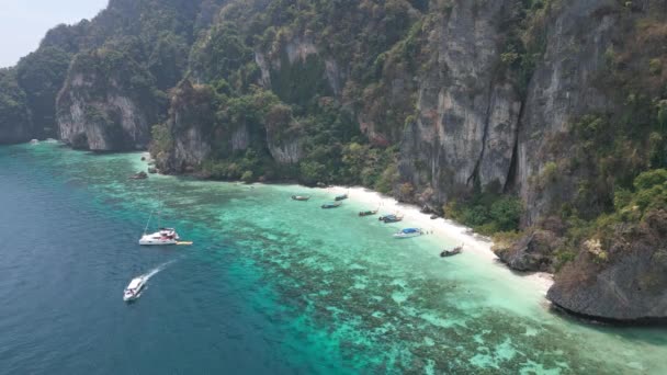 靠岸停着船 贡多拉 皮划艇在沙滩上靠近巨大的岩石 游艇和游客一起驶离海岸 无人机提供的空中图像 — 图库视频影像