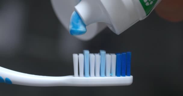在牙刷上涂牙膏 用浆糊挤压牙刷的刷毛 蓝色牙刷 蓝色薄荷牙膏 呼吸清新 牙齿洁白 口腔整齐 — 图库视频影像