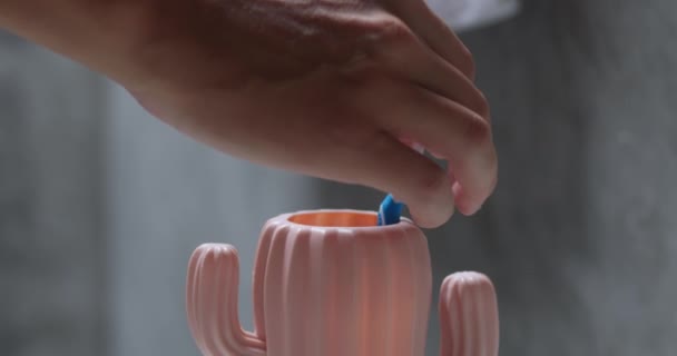 Αρσενικό Χέρι Βάζει Οδοντόβουρτσα Στο Κύπελλο Σημασία Της Καθημερινής Βούρτσισμα — Αρχείο Βίντεο