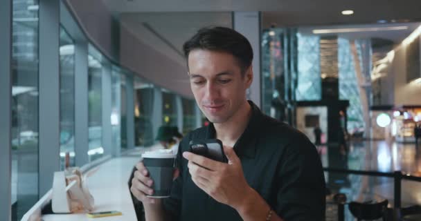 Άνθρωπος Που Κάθεται Στο Καφέ Πίνοντας Καφέ Τηλέφωνο Στο Χέρι — Αρχείο Βίντεο