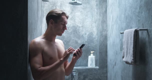 Man Stands Shower Types Messages Mobile Phone Types Intently Paying — Stock Video
