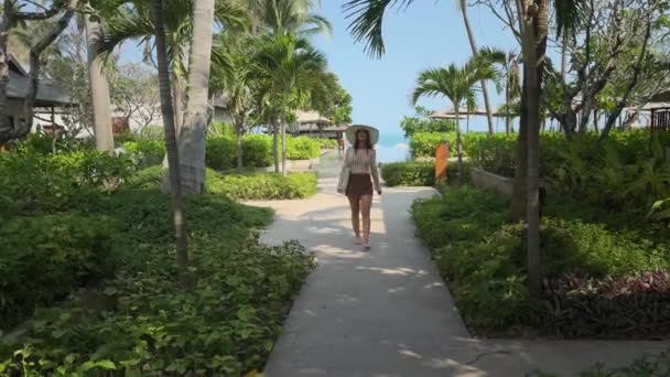 Носить Шляпу Женщина Ходит Среди Тропической Природы Недалеко Прибрежного Курорта — стоковое видео