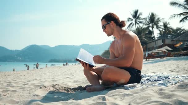 Uomo Siede Sulla Spiaggia Mare Tranquillamente Leggendo Libro Spiaggia Relax — Video Stock