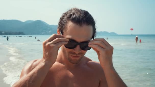Piedi Sullo Sfondo Uomo Mare Sulla Spiaggia Indossando Occhiali Sole — Video Stock