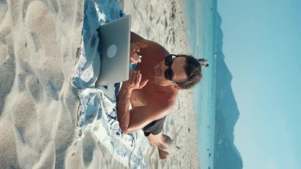 Uomo Occhiali Sole Sdraiato Spiaggia Sabbia Videochiamata Computer Portatile Verticale — Video Stock