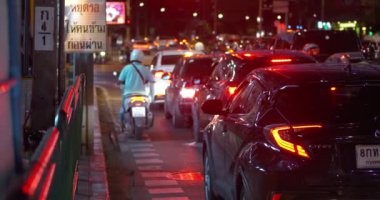 Hüzünlü sürücüler trafik sıkışıklığında yol alırlar. Pratiklik, trafik sıkışıklıklarını ve manevra kabiliyetini azaltır. Motosiklet sürücüleri trafik sıkışıklıklarını, kalabalık şehir ortamlarını, trafik sıkışıklığını Bangkok, Tayland - 19 Aralık 2023