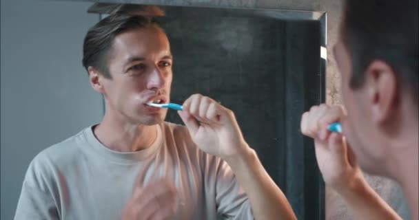 남자는 조심스럽게 욕실에서 치아를 닦아하지만 문제가 있습니다 과민한 때문에 고통스러운 — 비디오