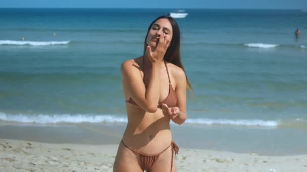 Mulher Magra Biquíni Praia Aplicando Cuidadosamente Protetor Solar Vista Frontal Videoclipe