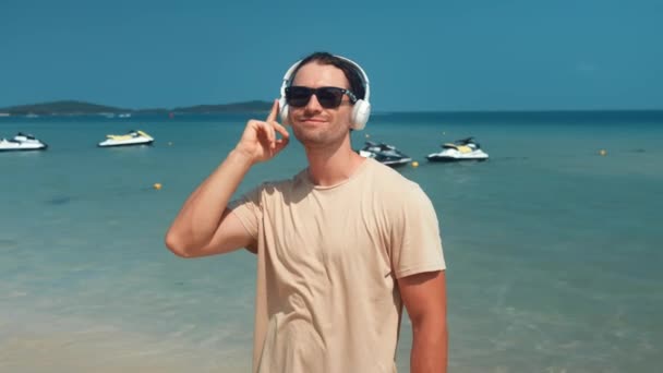 Uomo Che Ascolta Musica Cuffia Piedi Sulla Spiaggia Sullo Sfondo — Video Stock