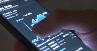 Cep telefonlu kişi kripto döviz piyasasını takip ediyor. Kripto para birimine yakın çekim. Kapsamlı finansal fırsatlar. Şifreleme para biriminin erişilebilirliği dijital çağda kazancı yeniden tanımlar