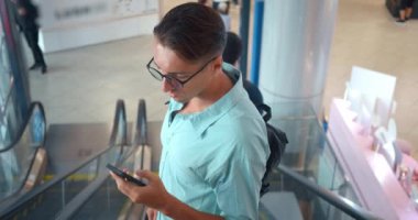 Genç adam cep telefonu kullanıyor ve metrodaki en alt kata yürüyen merdivenle iniyor. Milenyum adamı kuryeyle önemli bir mesaj yazar. Adam telefona bakar ve doğru yolu seçip seçmediğinden şüphe eder.