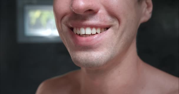 男はカメラを見つめ 彼の笑顔は美しいまっすぐな歯を示しています 放射線による健康の表現 歯科衛生は 全体的な幸福へのコミットメントを強調しています 明らかな優先順位 — ストック動画