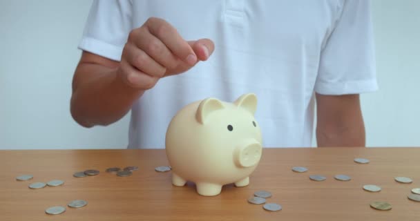 Man Confidently Puts Coin Ceramic Piggy Bank Preserving Savings Person — Stock Video