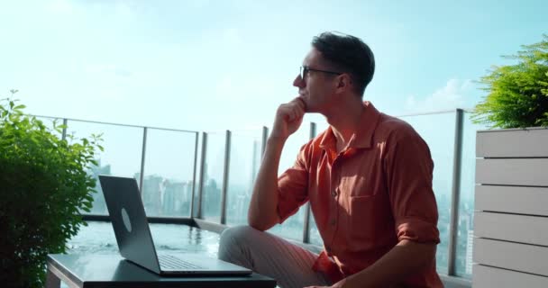 Mannen Funderar Sitter Laptop Nära Poolen Mot Stadsbilden Kvalitet Reflekterade — Stockvideo