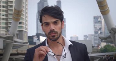 Klasik takım elbiseli iş adamı gözlüklü işadamı kameranın amacına ve çözümüne bakıyor. İş adamı, iş dünyasındaki başarı özüne karşı kendinden emin bir tutum sergiliyor